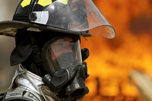 Firefighter in their fire proof suit and mask in fire training